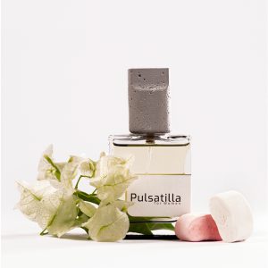 تصویر عطر پولساتیلا کلار 50 میل برای بانوان، کنار گل‌های سفید و پاستیلی – رایحه گلی، مرکباتی و پاستیلی